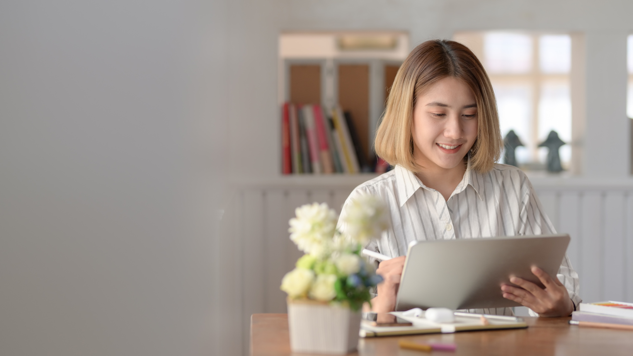 Photo of Smiling Woman in White Dress Shirt Using a Tablet